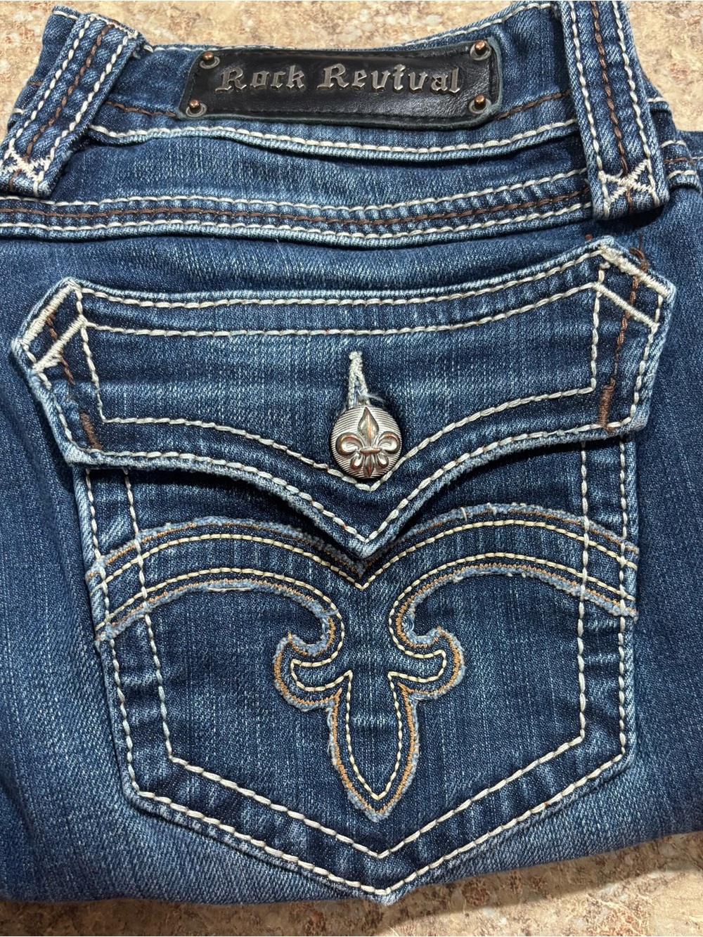 Rock Revival Blue Denim Bootcut Jeans with Embroidered Fleur-de-lis Pocket